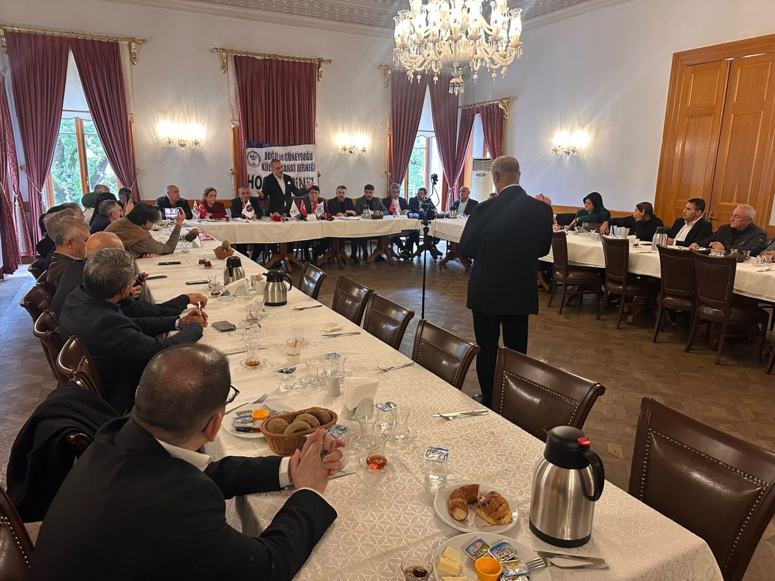 Dernek yönetim kurulu toplantısı: Adile Sultan Kasrı salonunda masalarda oturan katılımcılar
